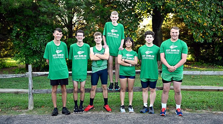 A group of Delaware Tech cross country athletes standing in their athletic uniforms